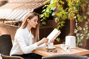 Canvas Print - Beautiful woman with blank book in cafe outdoors