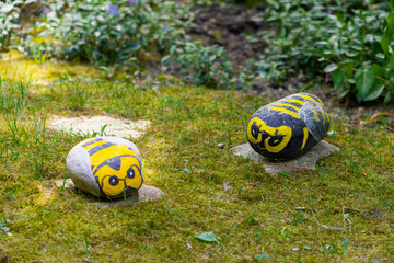 Handmade painted acrylic stone bee in garden