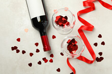 Bottle Of Wine And Glasses With Glitter And Ribbon On White Textured Table
