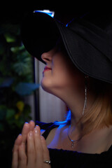 Portrait of fat plump chubby middle-aged woman with hat and black dress. Model looking as lady posing in studio.