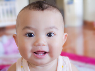 Portrait child little boy  6 months old with have have 2 teeth on blur image. he smile happy. cute and authentic. baby thai concept.