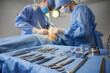 © anatoliy_gleb - Plastic surgery instruments on surgical table with medical team and patient on blurred background. Doctor and assistant performing aesthetic surgery. Concept of plastic surgery and medical instruments