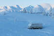 The frozen broken car will stand until spring. Winter landscape with a snow-covered car standing among the mountains in Yakutia, Sakha Republic