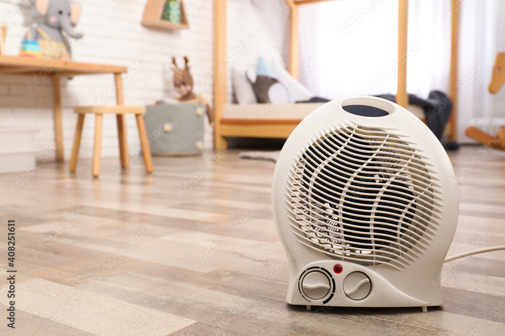Modern electric fan heater on floor at home. Space for text - obrazy, fototapety, plakaty 