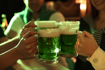 Wall Mural - People with beer celebrating St Patrick's day in pub, closeup