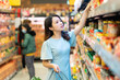 © Timeimage - Young girl is choosing to buy foodstuffs at the supermarket