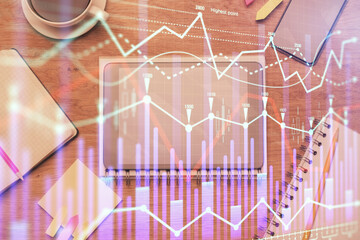 Double exposure of forex chart hologram over desktop with phone. Top view. Mobile trade platform concept.