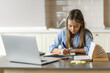 © Kateryna - Distance learning, homeschooling during quarantine. Caucasian pretty schoolgirl doing her homework at home using laptop, sitting at the work desk