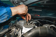 Auto mechanic man checks car engine under the hood