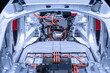 Chassis of the electric car with powertrain and power connections closeup. Blue toned. EV car drivetrain at maintenance.