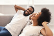 © Prostock-studio - Joyful African American Couple Relaxing Sitting On Couch At Home
