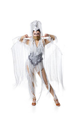 Wall Mural - Pointing. Beautiful young woman in carnival, stylish masquerade costume with feathers and golden face mask on white background. Concept of holidays celebration, festive time, dance, party, fashion