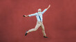 © DisobeyArt - Senior crazy man jumping outdoor with red wall in background - Happy mature dancing outside wearing safety face mask - Joyful elderly lifestyle concept - Focus on him