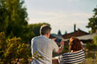 © DenisProduction.com - Back view mature man taking a photo on his smartphone. Adult senior couple enjoying the nature sitting outdoors on the grass.