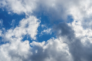 Wall Mural - bright blue sky shows through gaps in white-gray clouds. meteorology, clouds and wind. changing weat