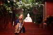 © Mike Uteshev - A girl in a beautiful garden and on the background of a buddha