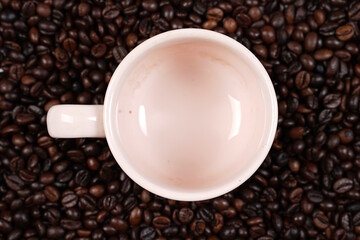 The scattered coffee beans came out of the white cup. Blend of coffee bean with cup isolated on background. Popular wallpaper on 2021. Template design for coffee shop.