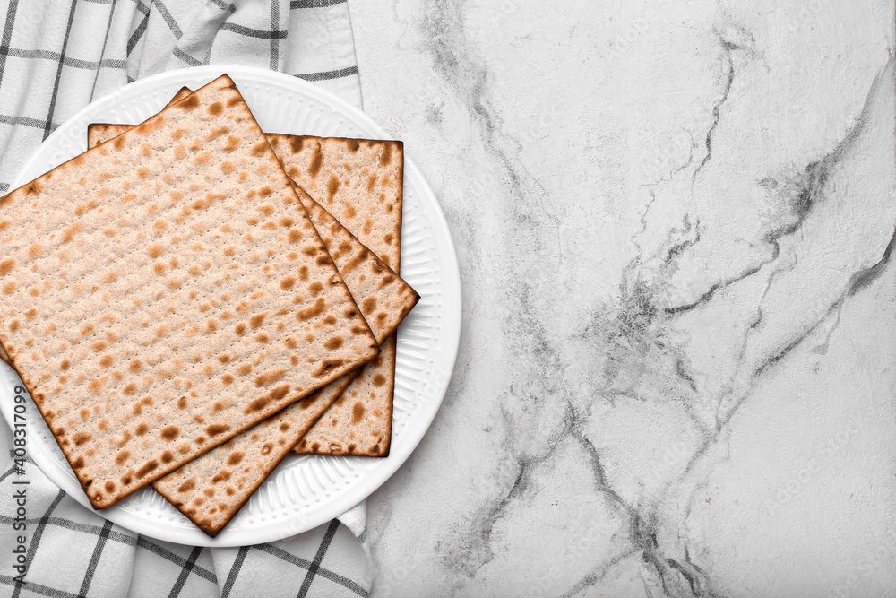 Plate with Jewish flatbread matza for Passover on light background