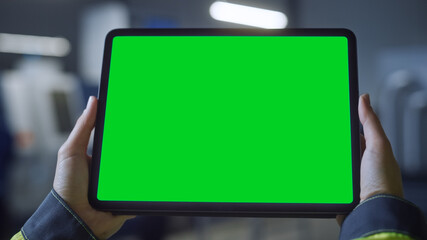 Wall Mural - Industry 4.0 Factory: Chief Engineer and Project Supervisor Holds Digital Tablet Computer with Green Screen, Chroma Key. Workshop with Machinery.