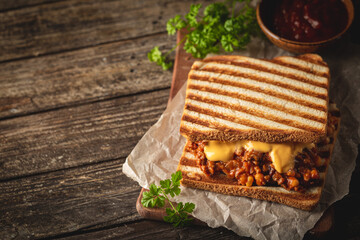 Wall Mural - Close up view of tasty sloppy joe sandwich with ground meat, sauce and cheese on wooden background