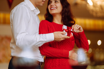 Wall Mural - Exchange of gifts.  Young couple in love offering gift to each other for valentine day or birthday. Romantic day. Winter holidays.