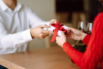 Wall Mural - Exchange of gifts.  Young couple in love offering gift to each other for valentine day or birthday. Romantic day. Winter holidays.