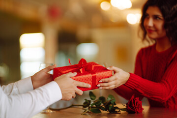 Wall Mural - Exchange of gifts.  Young couple in love offering gift to each other for valentine day or birthday. Romantic day. Winter holidays.