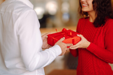 Wall Mural - Exchange of gifts.  Young couple in love offering gift to each other for valentine day or birthday. Romantic day. Winter holidays.