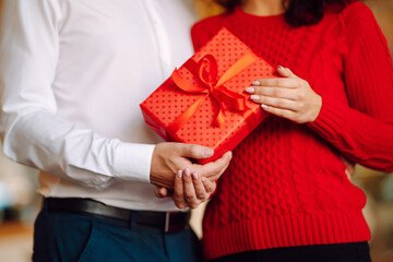 Wall Mural - Exchange of gifts.  Young couple in love offering gift to each other for valentine day or birthday. Romantic day. Winter holidays.