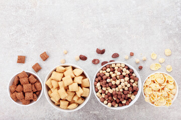 Poster - Various corn flakes in bowls on grey background