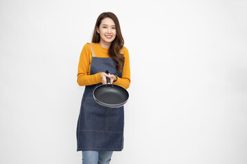 Young Asian woman housewife wearing kitchen apron cooking and holding pan isolated on white background