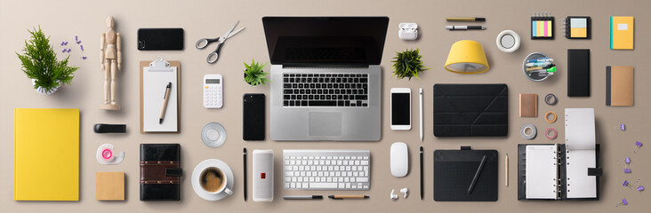 Flat lay top view office desk working space with laptop and supplies on gray background.