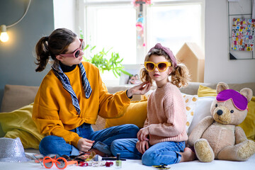 Wall Mural - Sisters indoors at home, playing on bed. Lockdown concept.