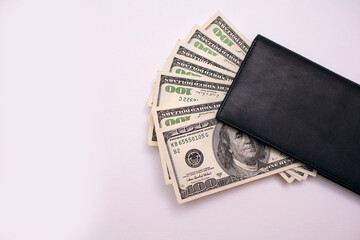 US dollars in a wallet on a white background top view