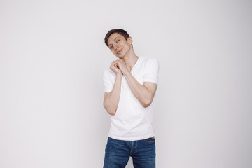 Portrait of smiling young man in a white t-shirt isolated on white background.