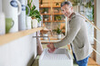 © Jo Kirchherr/Westend61 - Smiling mature man washing hands while standing by sink at home