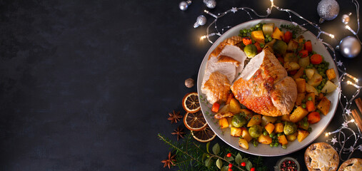 Wall Mural - Roasted turkey breast with potatoes, carrots, turnip and brussel sprouts. Christmas dinner table with decorations. View from above, copy space