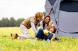 © GER/Westend61 - Three siblings playing on grass in front of pitched tent