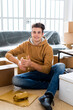 © Giorgio Fochesato/Westend61 - Smiling man packing wrapped drinking glass in box in new loft apartment