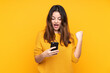 © luismolinero - Young caucasian woman isolated on yellow background surprised and sending a message