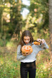 © xose casal/Westend61 - Surprised woman looking in Halloween pumpkin while standing at park
