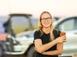 © Caro Telfer/Austockphoto - blonde bespectacled young woman outdoors holding beer bottle