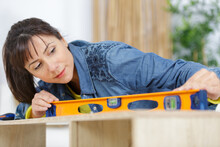 A Woman Measuring A Furniture