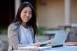 © Jonah Ritchie/Austockphoto - Young Asian female university student studying on laptop outdoors