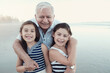 © Sammy Bailey/Austockphoto - Happy multicultural grandparent with grandchildren on the beach