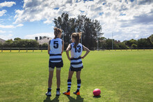 Two Girl AFL Players Standing On The Football Ground
