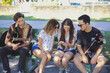© Sammy Bailey/Austockphoto - Multicultural teenagers hanging out and using mobile phone