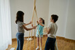 © Cavan Images - Children putting the sticks to build a teepee tent inside their house. Creativity concept