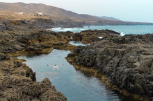Man Swimming And Relaxing In Natural Sea Pool On Fuerteventura Island.
