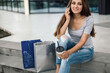 © zadorozhna - Woman using phone sitting near mall with coffee after shopping.